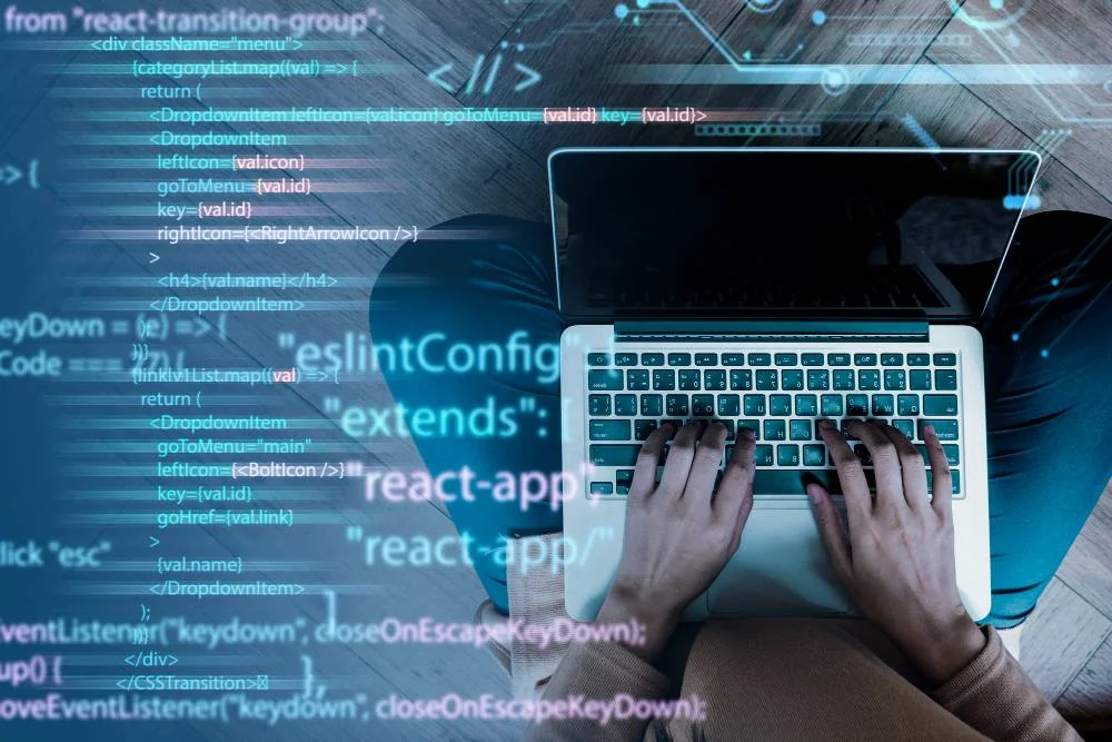 Developer using a laptop with website code visible